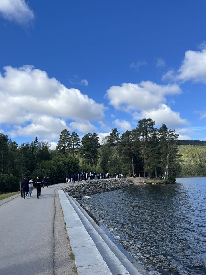 En gruppe mennesker som går langs en elv En gruppe mennesker som går langs en elv