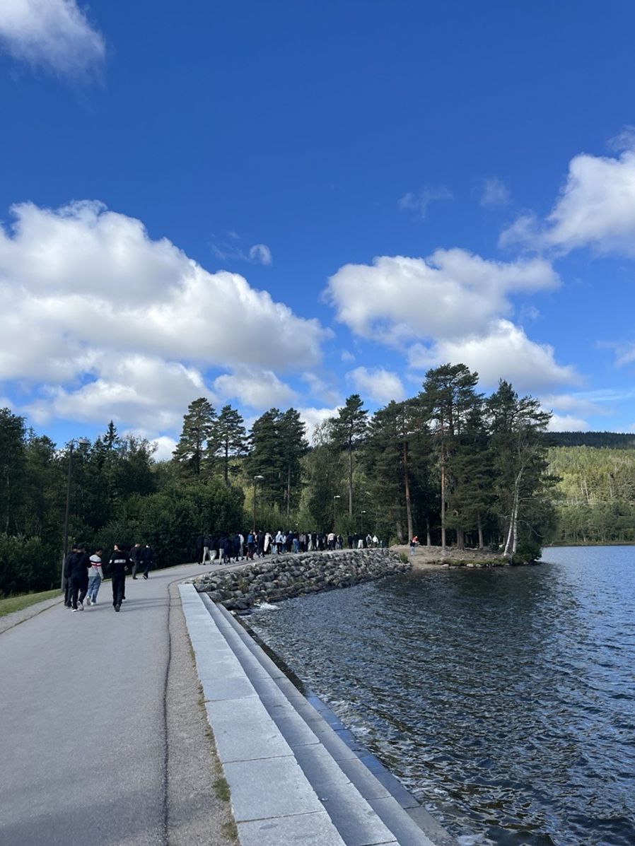 En gruppe mennesker som går langs en elv