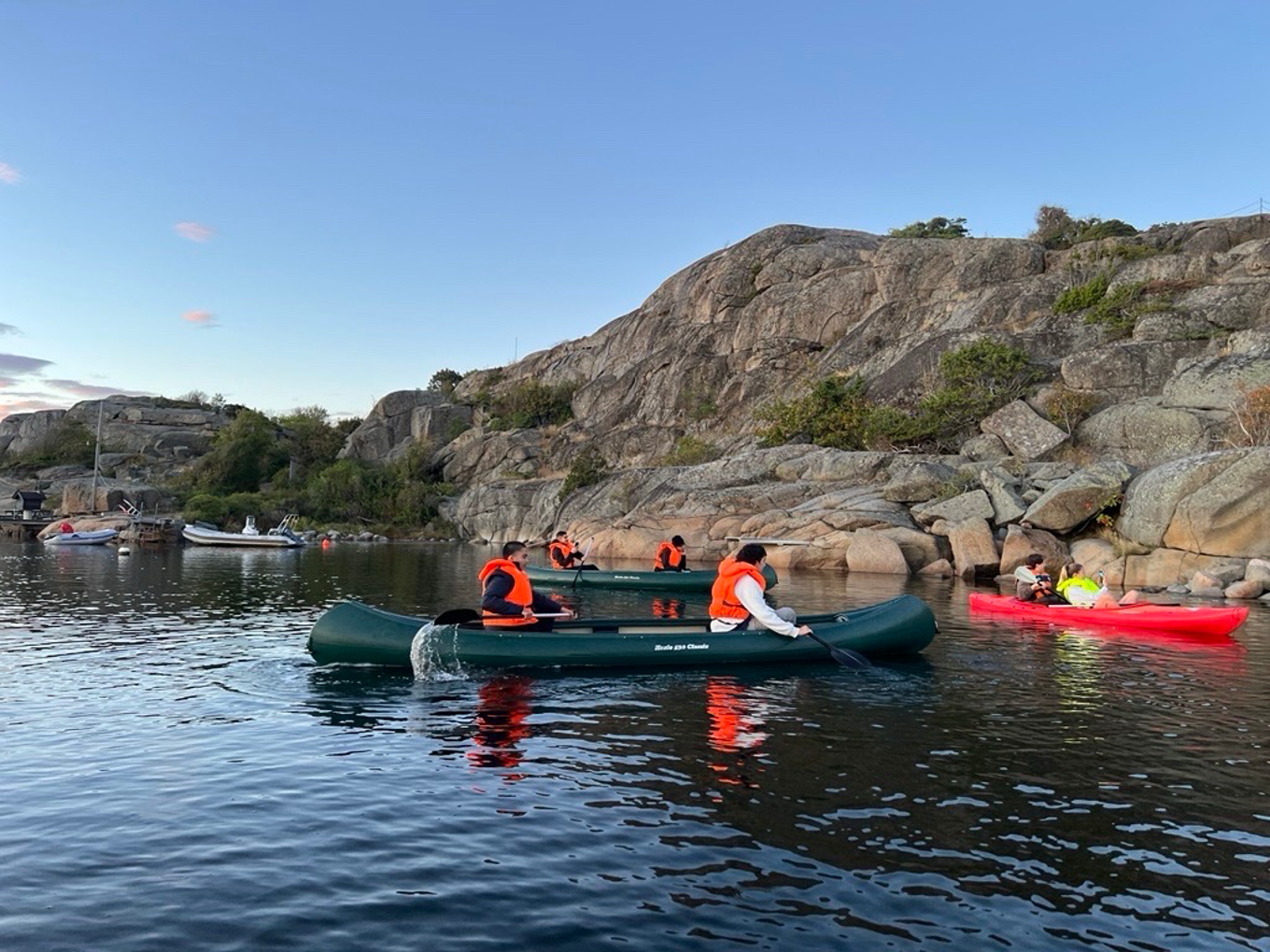 En gruppe mennesker i kajakker på en innsjø En gruppe mennesker i kajakker på en innsjø