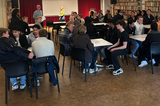 en gruppe mennesker som sitter i et rom
