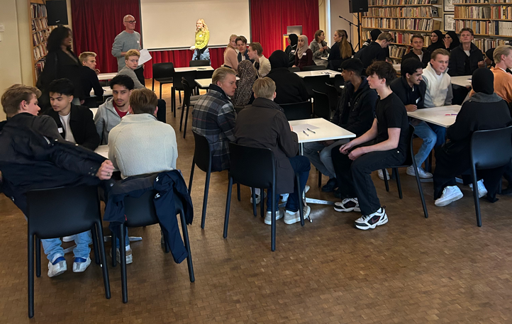 en gruppe mennesker som sitter i et rom