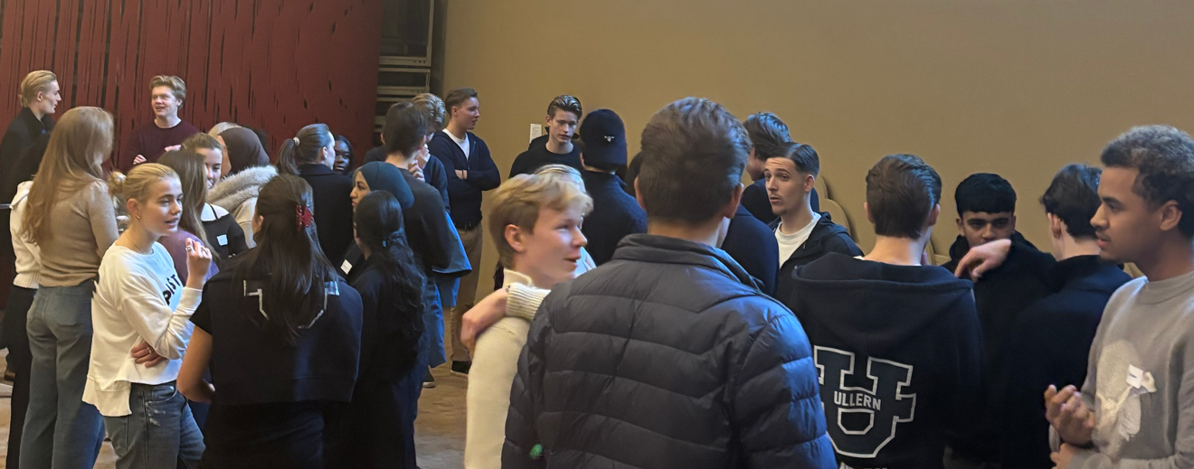 en gruppe mennesker som står i et rom en gruppe mennesker som står i et rom