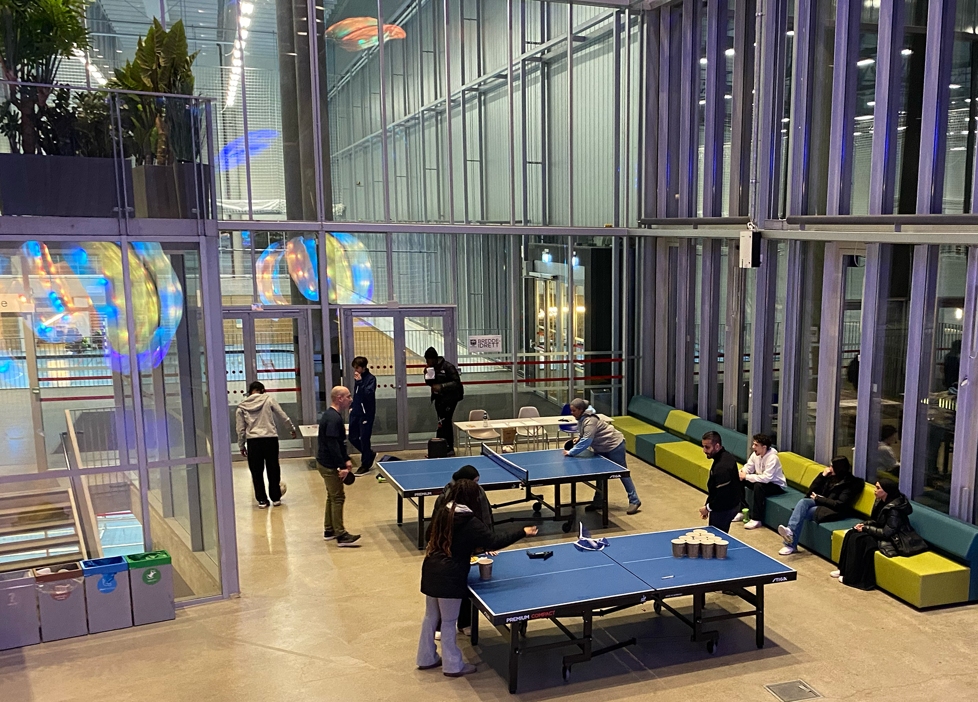 mennesker i et rom med bord og stoler