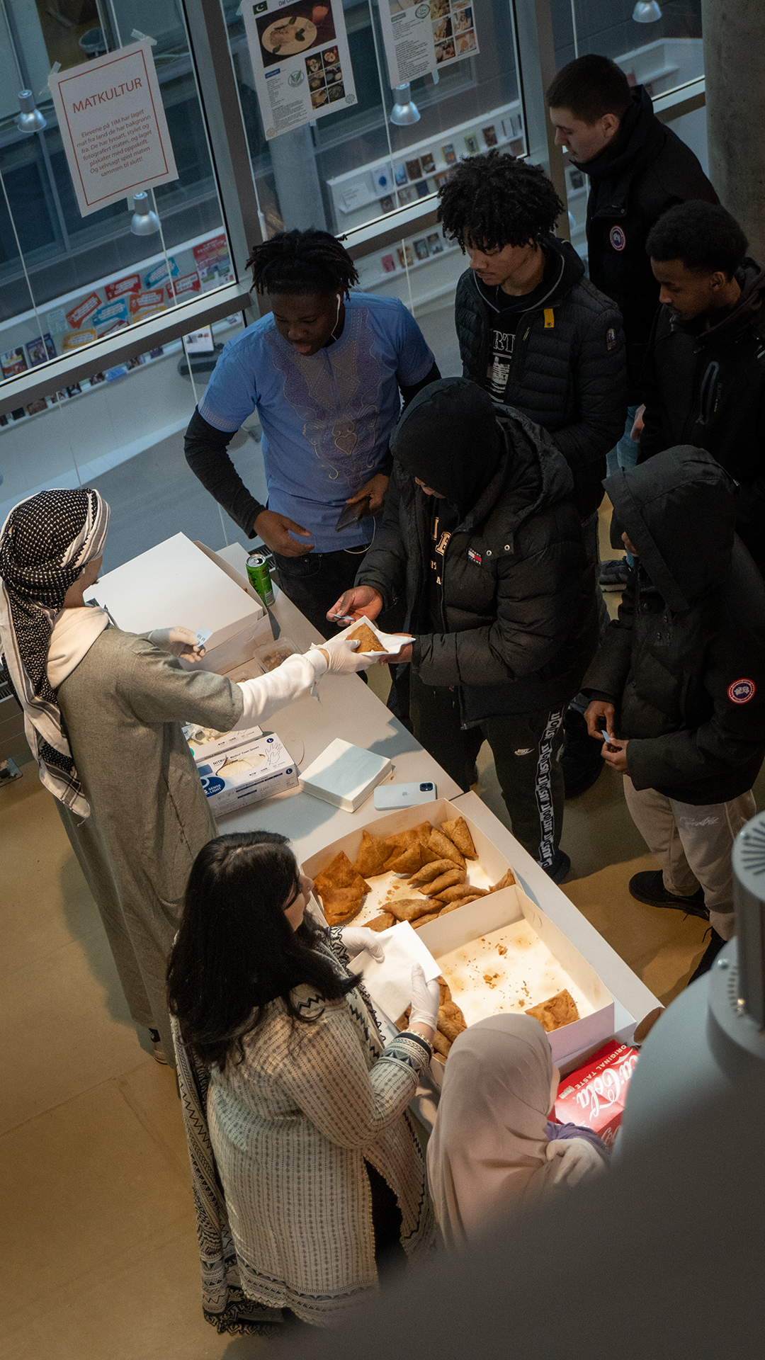En gruppe mennesker samles rundt et bord med smultringer