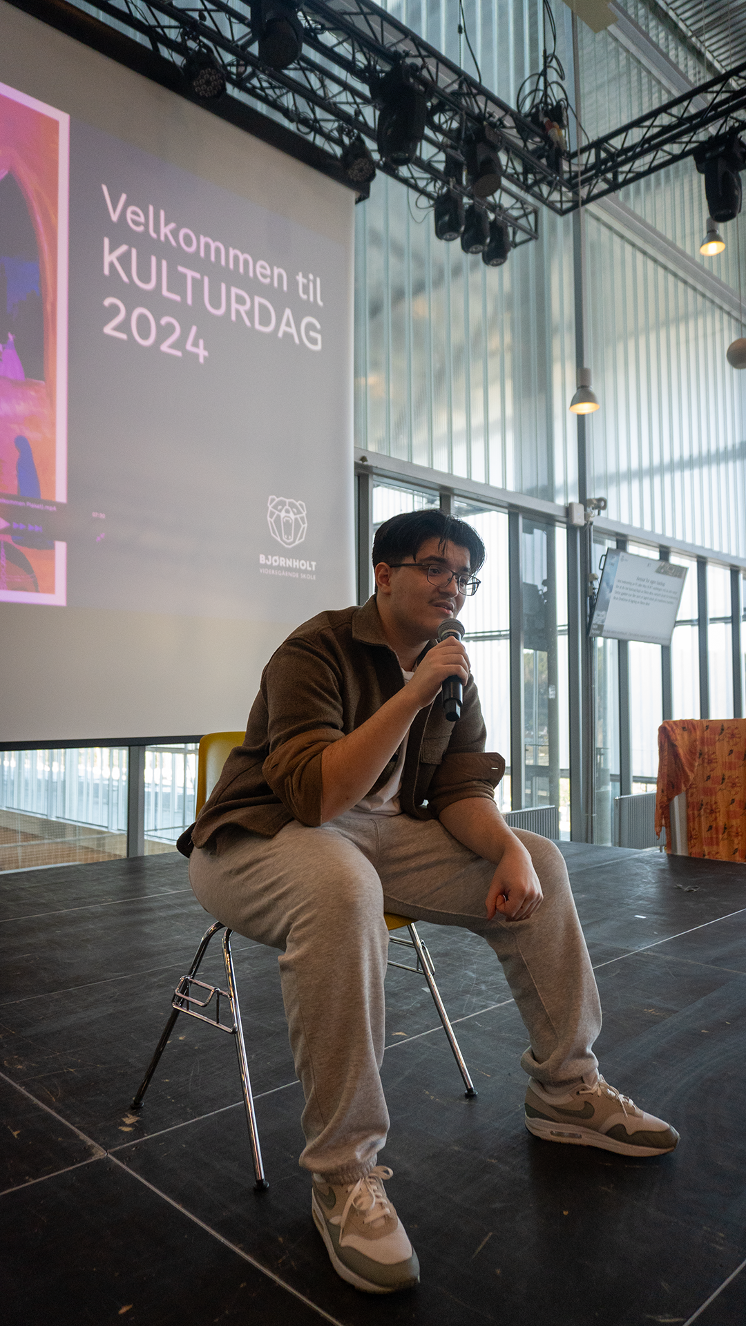 en person som sitter i en stol og holder en mikrofon