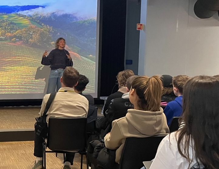 En person som holder en presentasjon for en gruppe mennesker En person som holder en presentasjon for en gruppe mennesker