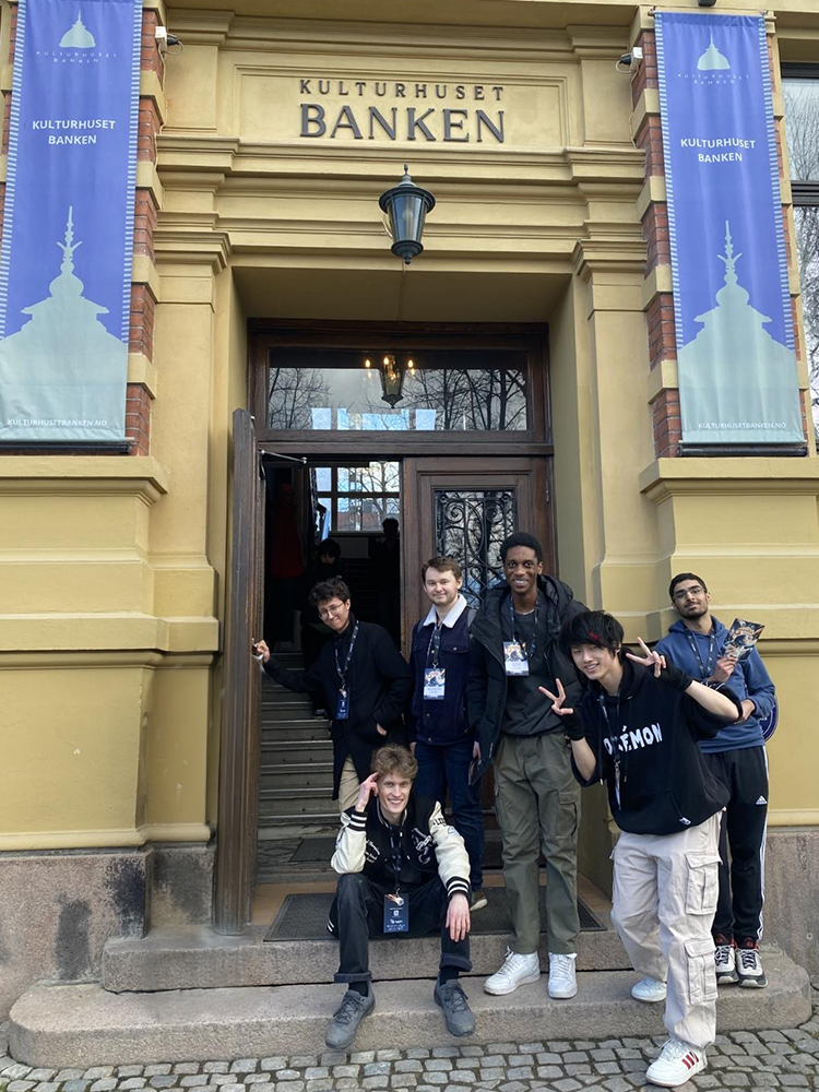 en gruppe mennesker som poserer for et bilde utenfor en bygning