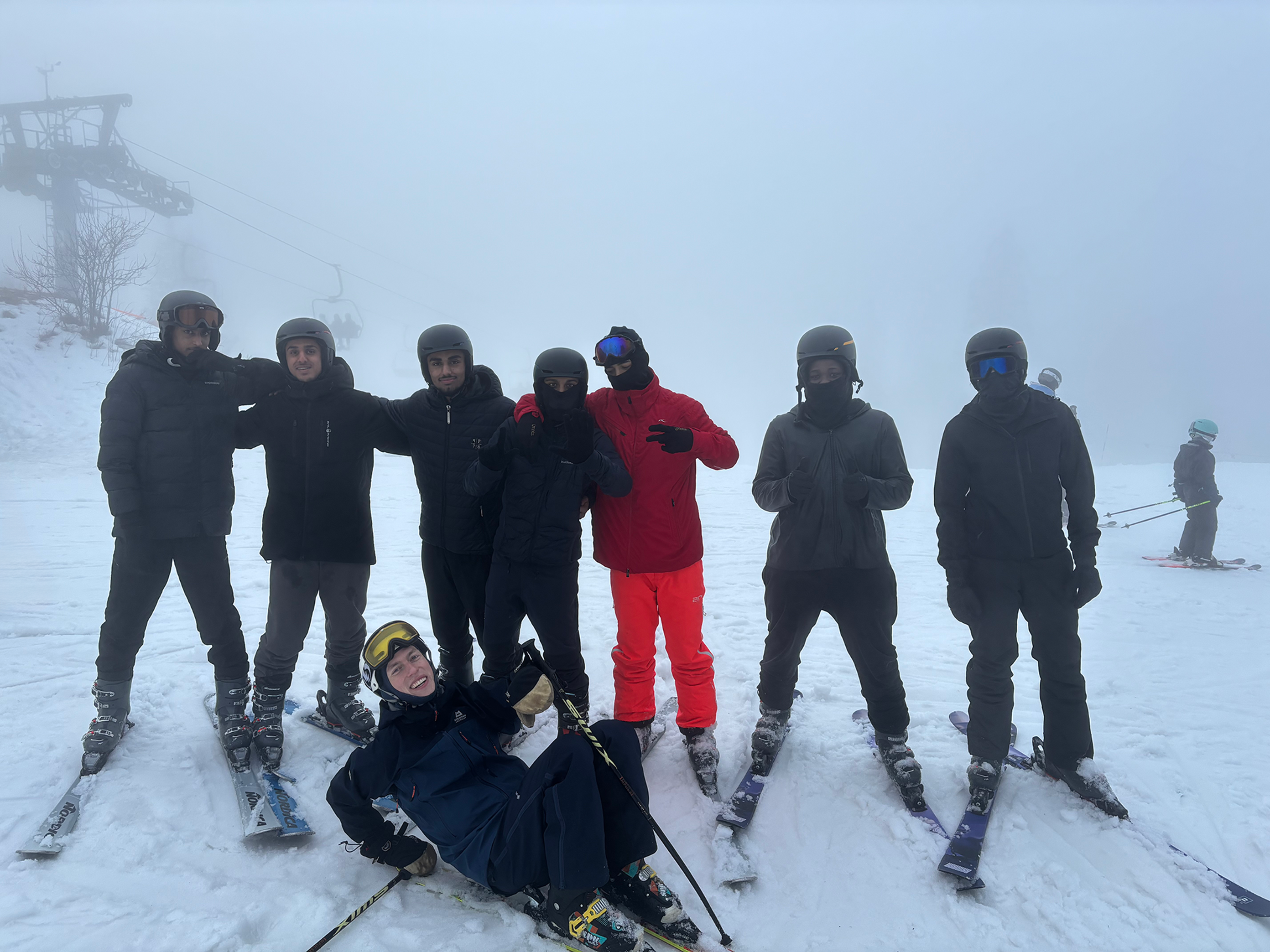 En gruppe mennesker poserer for et bilde på snøski En gruppe mennesker poserer for et bilde på snøski